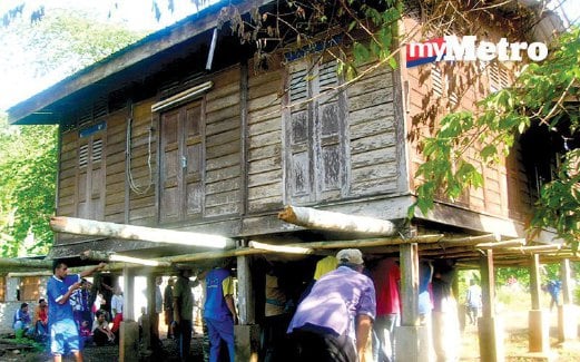 PENDUDUK Kampung Katong, Pauh, Perlis bergotong-royong mengusung sebuah rumah kayu.
