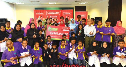 AZIZAH (bertudung merah) menyampaikan sumbangan Colgate-Palmolive Malaysia kepada wakil rumah kebajikan.