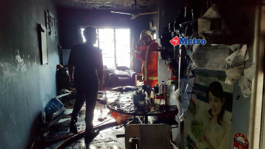 Anggota bomba menjalankan pemeriksaan keadaan rumah pangsa yang terbakar. FOTO Hamzah Osman