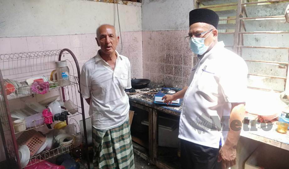 MD Nayan (kanan) meninjau dapur kediaman Saat. FOTO Shaiful Shahrin Ahmad Pauzi 