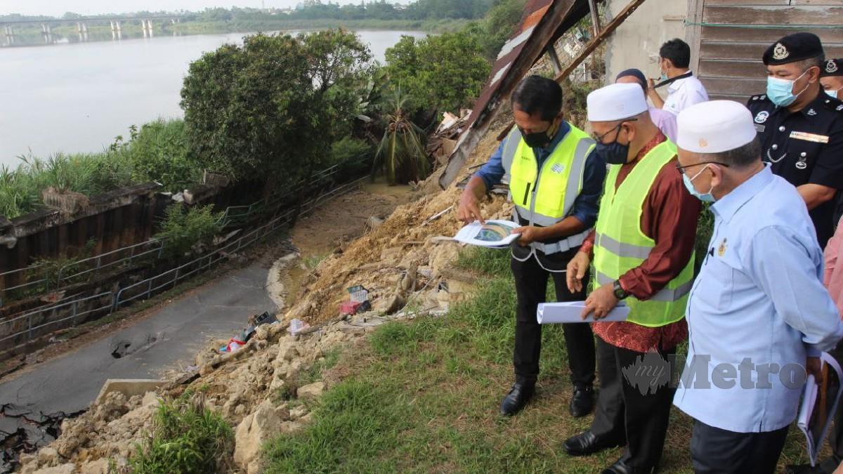 Tuan Ibrahim diiringi oleh Pengarah JPS Kelantan Kamal Mustapha (kanan) ketika meninjau tebing Sungai Kelantan di Kampung Pohon Celagi, Pasir Mas yang runtuh. Foto Nik Abdullah Nik Omar 