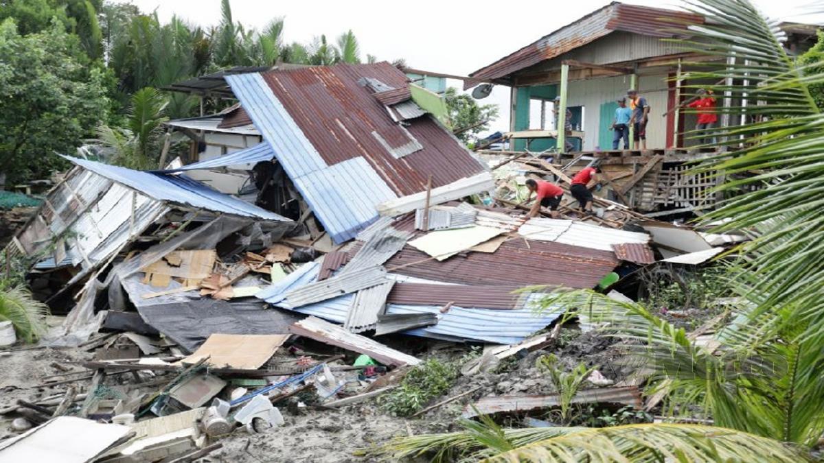 DUA keluarga terselamat dalam kejadian runtuhan di Kampung Tambirat Tengah, di sini, malam tadi. FOTO NADIM BOKHARI 