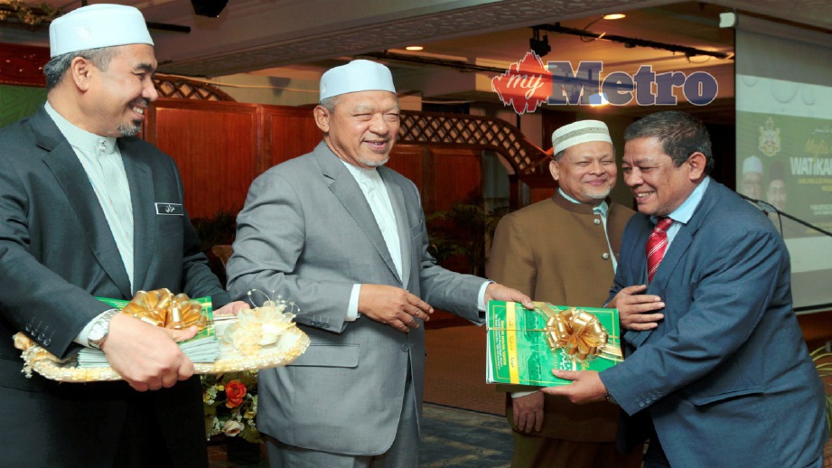AHMAD (dua kiri) bersama Mohd Amar (dua kanan) dan Dr Izani (kiri) menyampaikan watikah perlantikan kepada Yang Dipertua Majlis Daerah Bachok (MDB) Nik Mohamed Noor Nik Ishak (kanan) pada majlis penyampaian Watikah Perlantikan Ahli Majlis Pihak Berkuasa Tempatan (PBT) Negeri Kelantan di Kompleks Kota Darulnaim, hari ini. FOTO Syamsi Suhaimi
