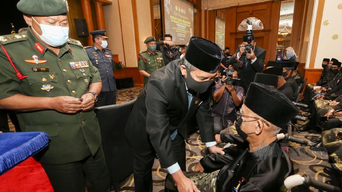 IKMAL Hisham memyematkan Anugerah Pingat Jasa Malaysia (PJM) kepada Md Nor Yaacob. FOTO Nik Abdullah Nik Omar