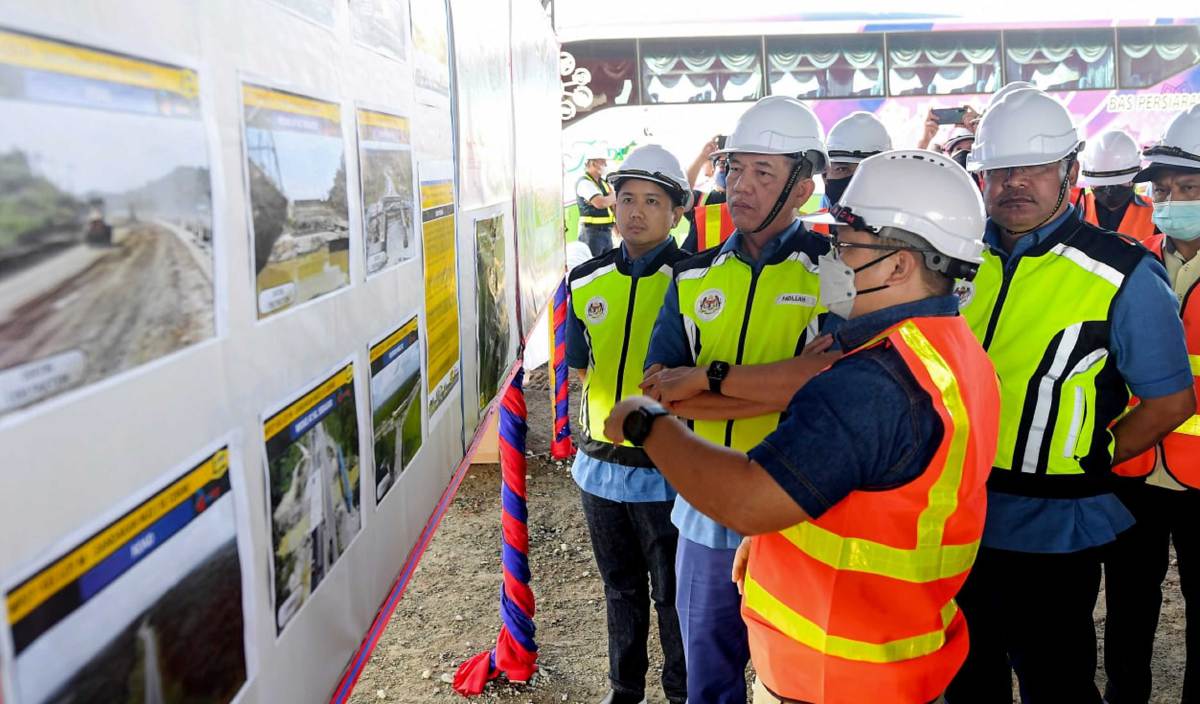 FADILLAH (dua, kiri) diberikan taklimat mengenai pembinaan lebuhraya Pan Borneo sewaktu meninjau pembinaan Lebuhraya Pan Borneo. FOTO BERNAMA