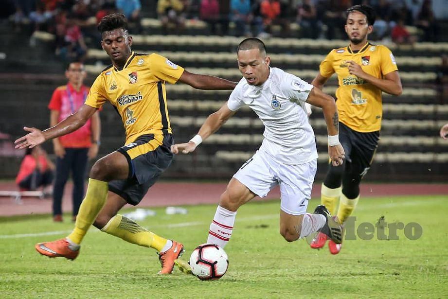 Pemain Sabah, Alto Linus (tengah) melepasi pemain Negeri Sembilan, Kalaiharasan Letchumanan dalam perlawanan Liga Perdana. FOTO Khairull Azry Bidin