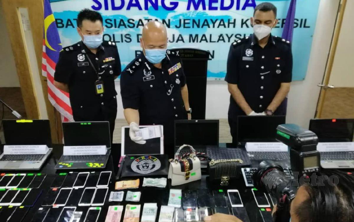  PEGAWAI JSJK Bukit Aman menunjukkan barangan dirampas dalam serbuan di sekitar Lembah Klang terhadap sindiket pusat panggilan penipuan pelaburan saham dalam talian di China pada 23 Oktober lalu.FOTO ihsan polis