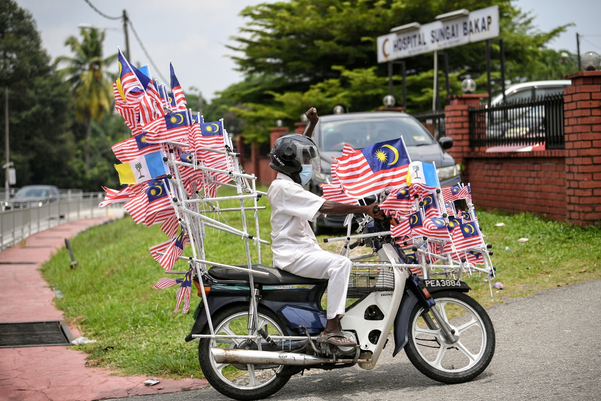 SAHUL Hamid menunggang motosikalnya yang dihiasi kira-kira 300 hingga 450 bendera mini Jalur Gemilang. FOTO Bernama