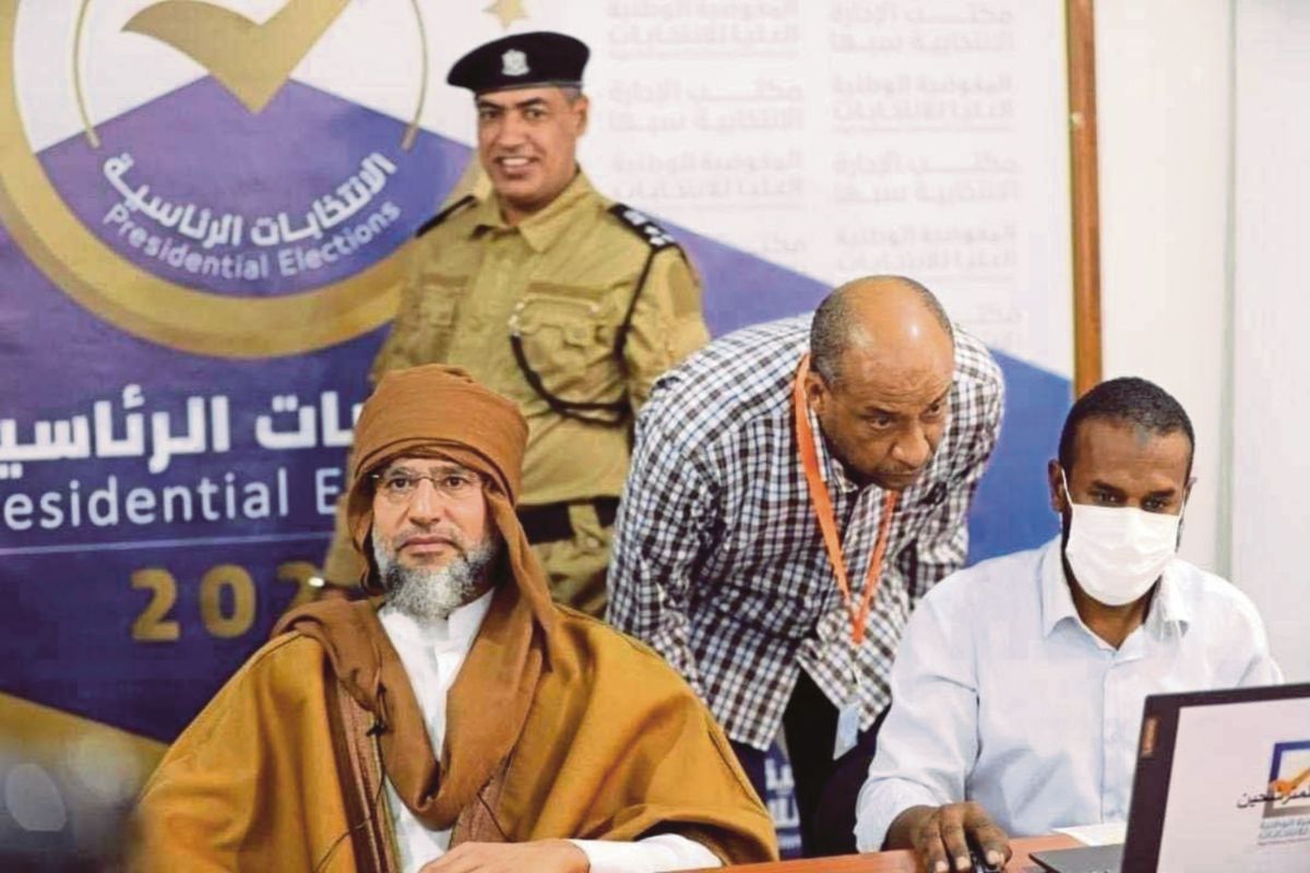FOTO menunjukkan Saif al-Islam Gaddafi (kiri) mendaftarkan diri sebagai calon pilihan raya presiden. FOTO EPA 