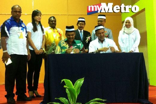 Ismail  (berdiri tengah) menyaksikan Mohd Rofik (kiri) dan Shaharuddin  (kanan) menandatangani MoU kad Subsidi pada majlis perasmian mesyuarat agung tahunan Kali ke-4 di Dewan Raya Putra Bandar Putra di Kulaijaya, hari ini. FOTO Redzuan Muharam