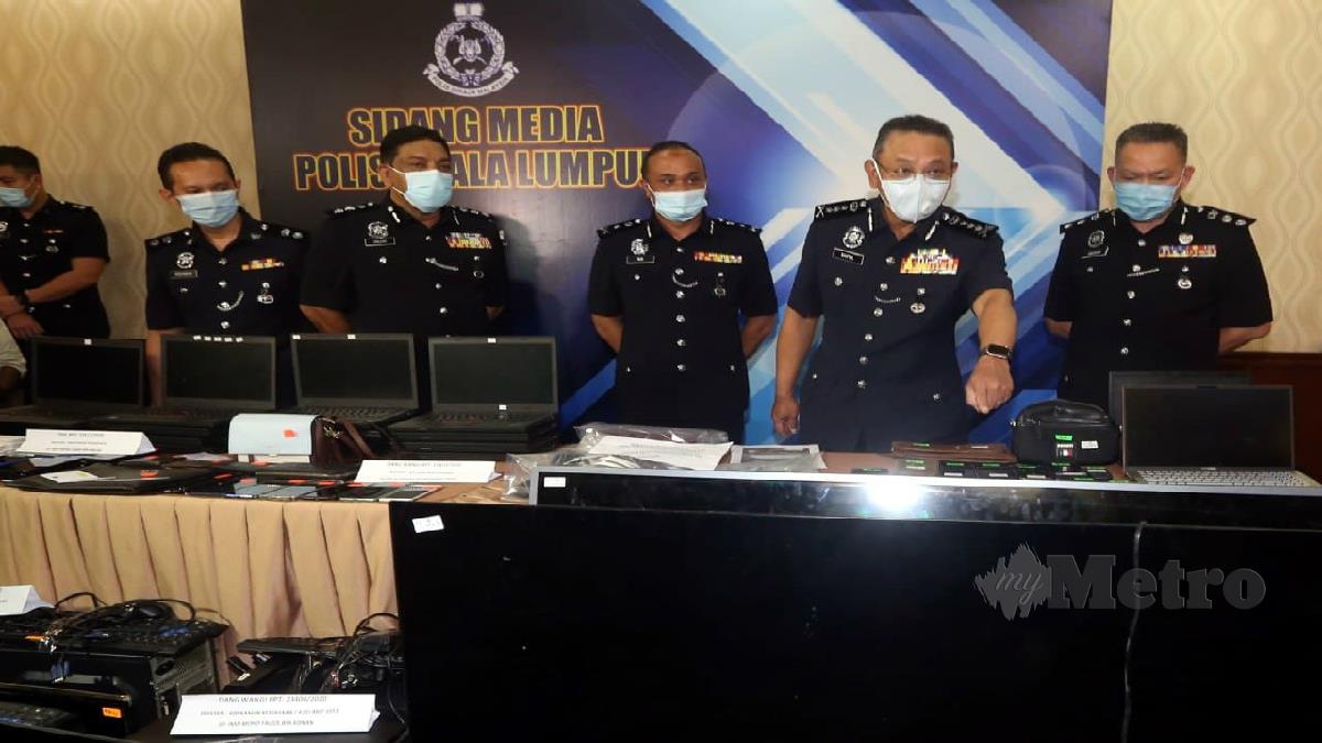 Saiful Azly (dua kanan) menunjukkan sebahagian peralatan sindiket penipuan dan judi online yang dirampas ketika sidang media di IPK Kuala Lumpur. FOTO Hairul Anuar Rahim 