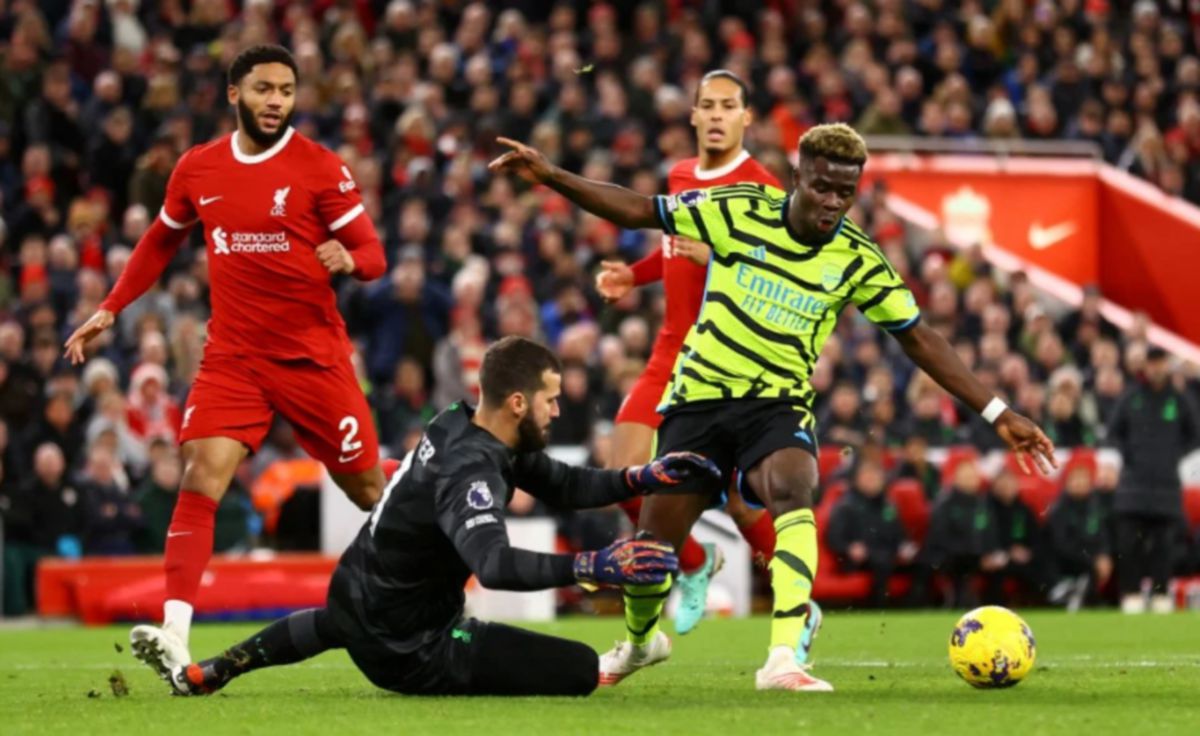 PENYERANG Arsenal, Bukayo Saka (kanan) berdepan penjaga gol Liverpool, Alisson pada aksi EPL di Anfield, Liverpool awal pagi tadi. FOTO Reuters