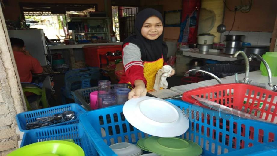 IZA Lydiatul Husna Mohd Rosli, 17, sedang mencuci pinggan di kedai milik ibu saudaranya. FOTO SYAHERAH MUSTAFA