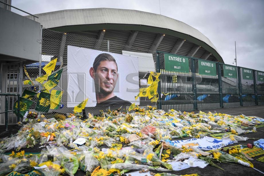 BUNGA kuning diletakkan di depan potret Sala di Stadium Beaujoire di Nantes, Perancis. - FOTO AFP