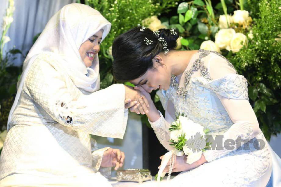 Ibu Syafie Naswip, Noorsiah Ahmad menyarungkan cincin pertunangan di jari manis Aisyah yang berlangsung di Forest Valley Hall. -Foto ROHANIS SHUKRI.