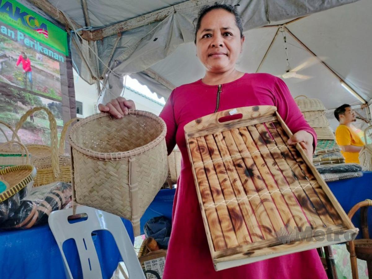 SALINA menunjukkan produk kraftangan Orang Asli yang dijual di gerainya. Foto Noorazura Abdul Rahman