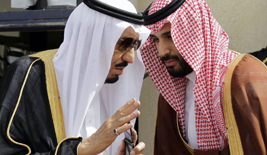 Raja Salman (kiri) bercakap sesuatu kepada anaknya, Putera Mahkota Mohammed Bin Salman, pada satu majlis di Riyadh pada 2012. - Foto Fail