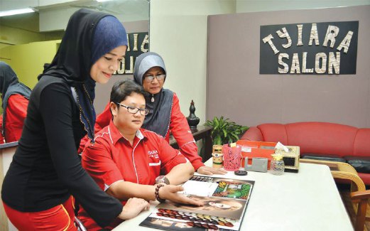 RAJA Zairina (duduk) bersama rakan perniagaannya di Tyiara Salon, Klang, Selangor.