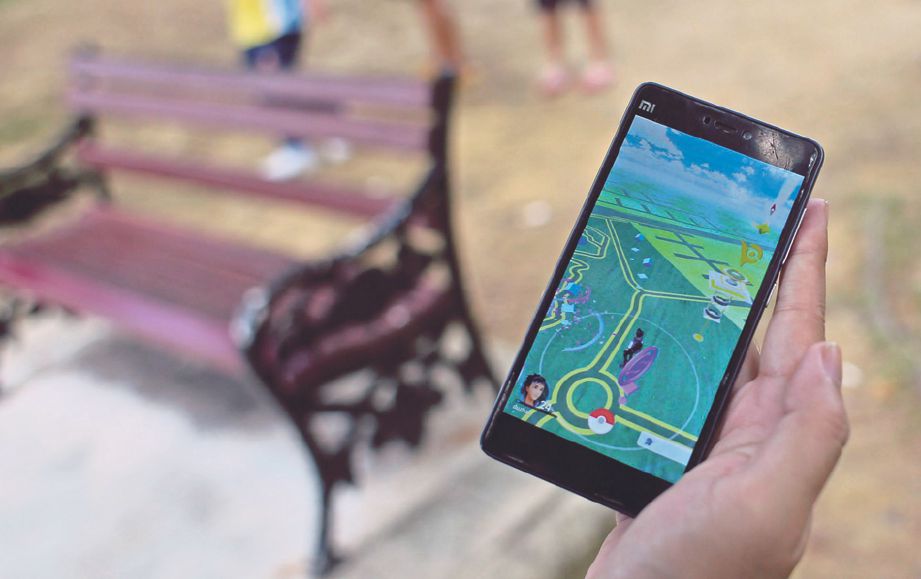 SEBAHAGIAN pengguna bermain permainan Pokemon pada telefon pintarnya di sekitar Tasik Taman Jaya.