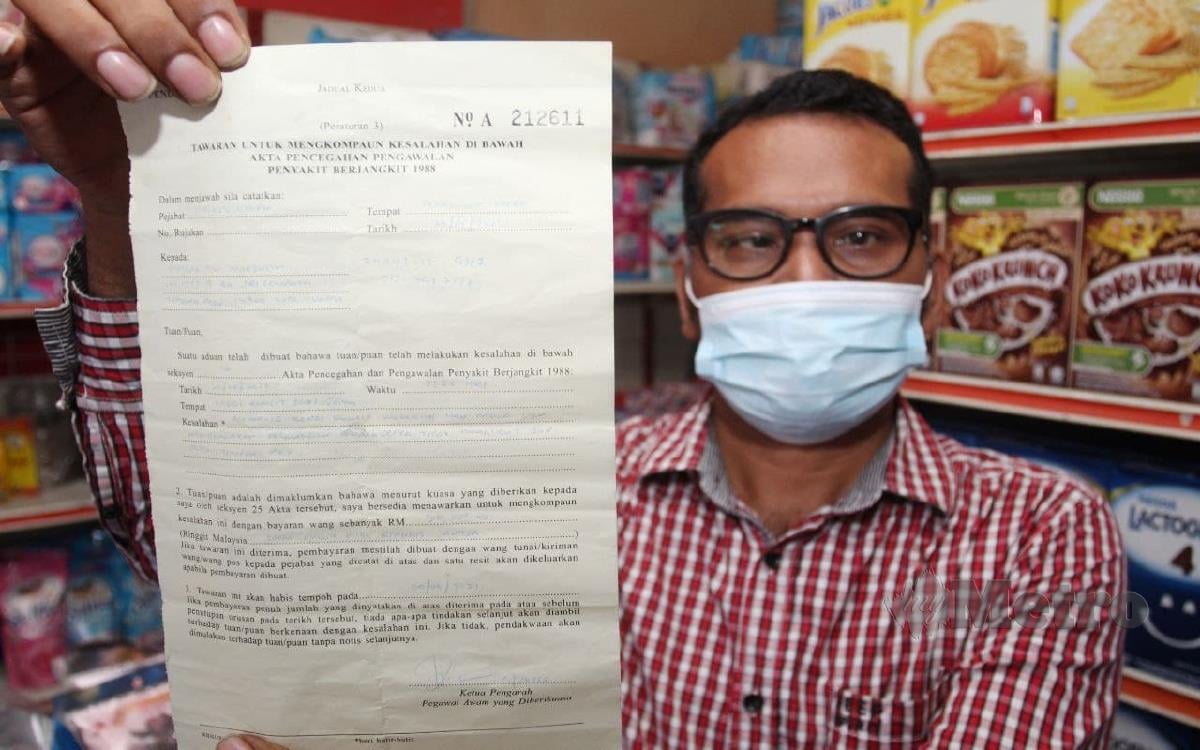 MANSAH menunjukkan surat kompaun RM50,000 yang dikeluarkan pihak polis. FOTO Nik Abdullah Nik Omar.