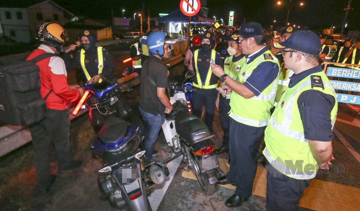 ZAILANI (dua kanan) bersama anggotanya memeriksa motosikal ketika meninjau Op HRA yang dijalankan di jalan Kota Bharu-Pasir Pekan. FOTO Nik Abdullah Nik Omar