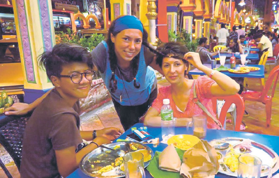 ALEXANDRA (tengah) bersama rakan menikmati makanan tempatan kegemarannya iaitu nasi lemak dan roti canai.