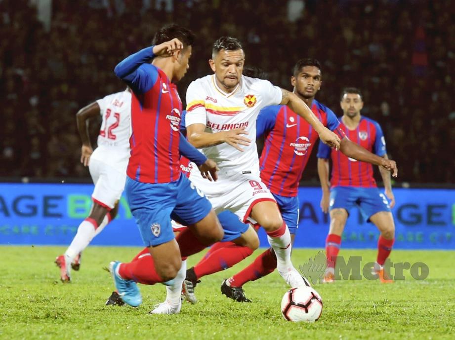 Pemain JDT, Muhd Safawi Rasid (kiri) berebut bola dengan pemain Selangor, Sandro Da Silva. 