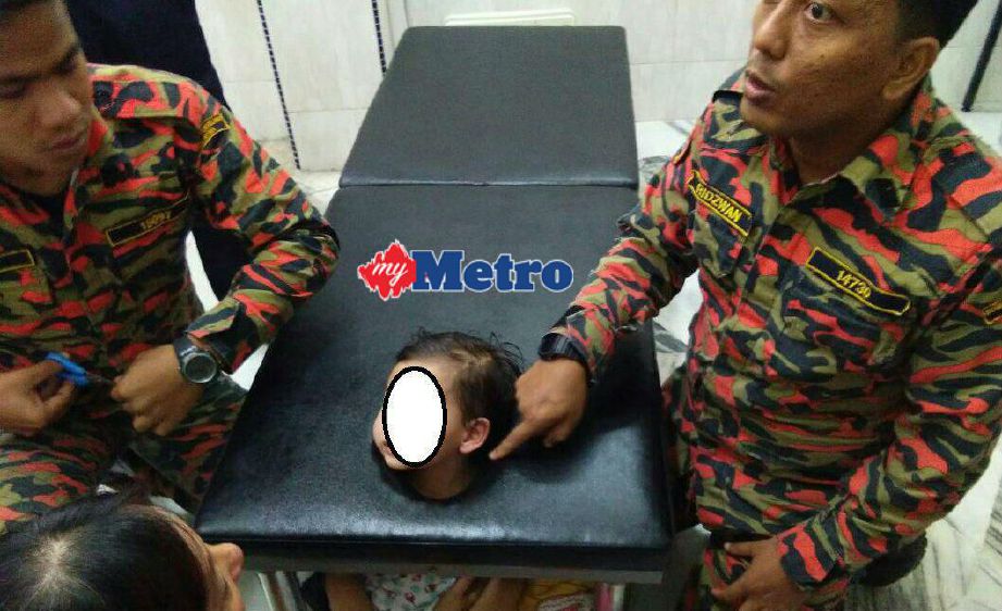 Kepala kanak-kanak tersangkut pada lubang katil urut di pusat mengurut di Jala Temenggong, Taman Ros, hari ini. FOTO ihsan bomba