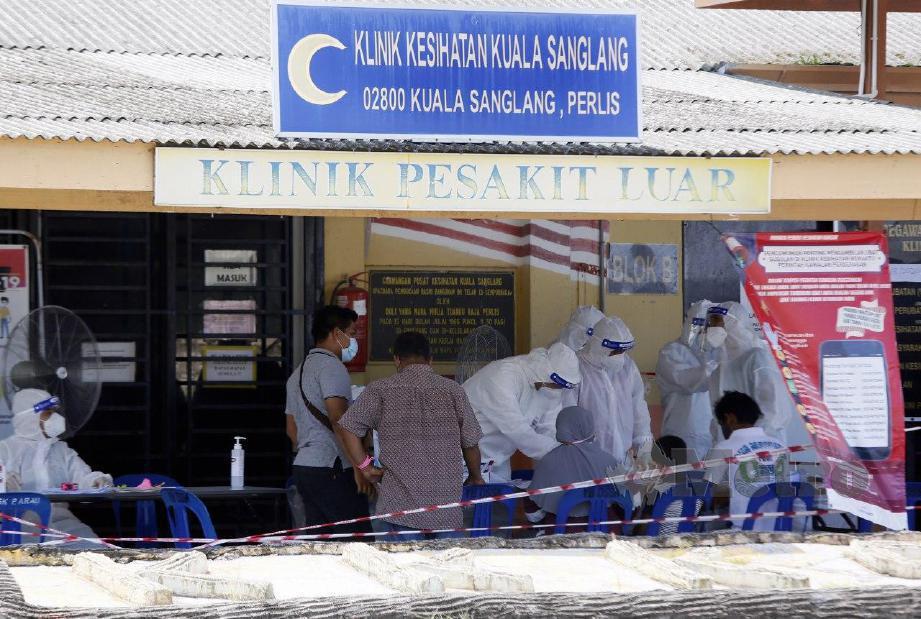 KAKITANGAN Kementerian Kesihatan Malaysia (KKM) memantau penduduk setempat yang hendak melakukan  proses saringan di Klinik Kesihatan Kuala Sanglang berikutan penularan Covid-19  yang dikaitkan dengan Kluster Sivagangga. FOTO Amran Hamid