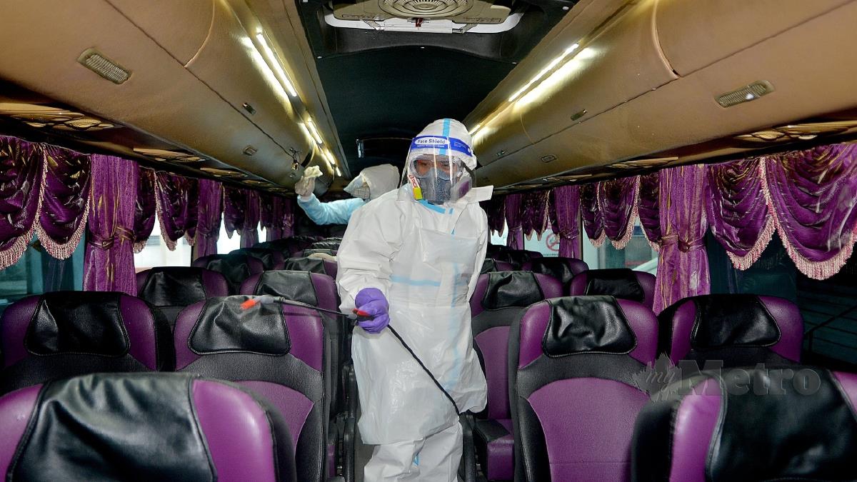 PETUGAS melakukan sanitasi di dalam bas bagi membuat persediaan penghantaran pulang penuntut UiTM mulai esok. FOTO Faiz Anuar. 
