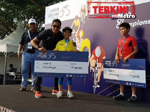 Darwish Putra menerima replika cek hadiah kemenangan RM30 daripada Khairy. FOTO ihsan Mohd Sanusi