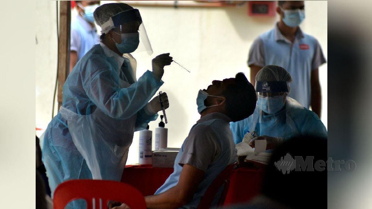 PETUGAS kesihatan melakukan ujian saringan Covid-19 terhadap pekerja kilang warga asing kumpulan syarikat Kossan di Meru, Klang. FOTO Faiz Anuar