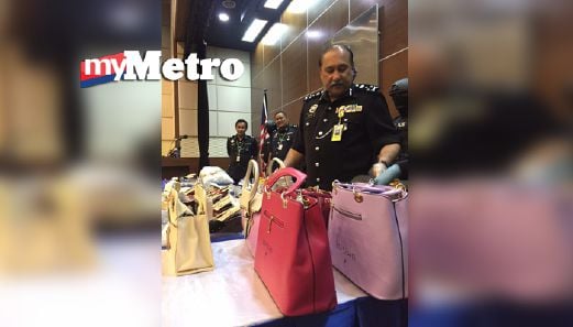 Mokhtar menunjukkan sebahagian beg tangan digunakan untuk menyimpan dadah dalam sidang media di Bukit Aman, hari ini. FOTO Hafidzul Hilmi Mohd Noor