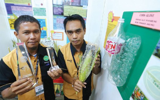 JOHAIRY dan Mohd Raduan menunjukkan sarung jagung dan plak yang diterima.