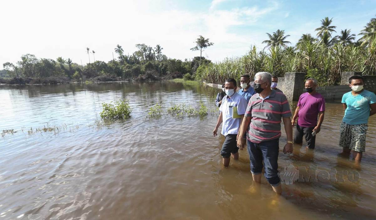 SEBAHAGIAN 40 pesawah memantau air banjir 'termenung' yang menenggelami 156 hektar sawah milik mereka di Kampung Tersang dan Kampung Luar, Gual Periok, ketika ditemui di kawasan sawah Kampung Luar, Gual Periok. FOTO Nik Abdullah Nik Omar