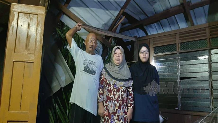 Norsalimah (kanan) bersama ibu bapanya Arifin Hussin dan Zaleha Idris menunjukkan ruang tamu rumah yang rosak dihempap pokok kelapa sawit akibat ribut di Sungai Kelat, Muar petang tadi. FOTO Badrul Kamal Zakaria 