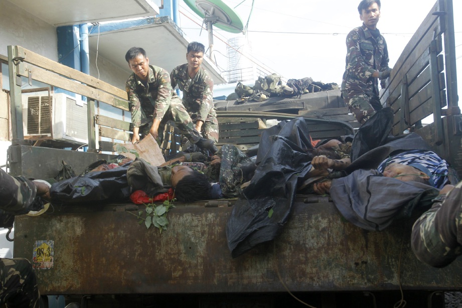 Tentera Filipina menurunkan mayat anggota Abu Sayaf dari atas lori selepas pertempuran di Patikul, Sulu. - Foto EPA