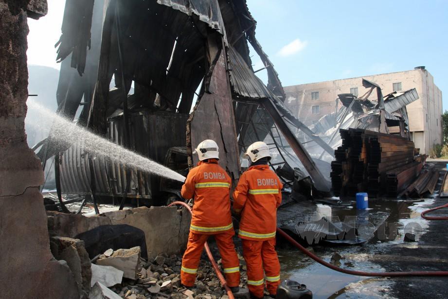 ANGGOTA Jabatan Bomba dan Penyelamat Malaysia (JBPM) Kelantan bertungkus lumus memadamkan api kebakaran sebuah kilang simpanan minyak pelincir. FOTO NIK ABDULLAH NIK OMAR