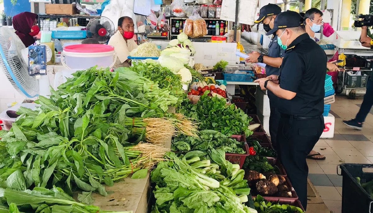 ANGGOTA penguatkuasa KPDNHEP sedang memeriksa harga sayur-sayuran yang dijual peniaga di Pasar Besar Sena, Kangar hari ini. FOTO IHSAN KPDNHEP PERLIS