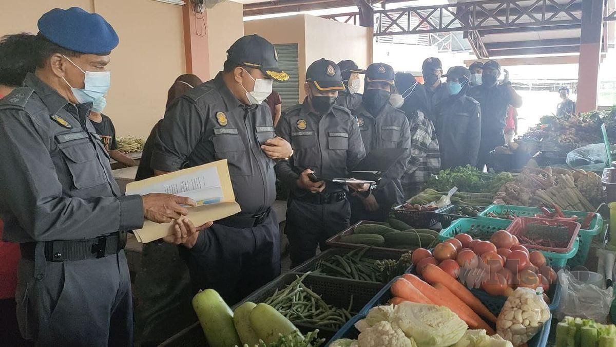 Shamsul Nizam (dua dari kiri) melakukan pemeriksaan harga sayur-sayuran di Pasar Awam Jitra untuk memastikan harga sayuran tidak naik mendadak. FOTO ZULIATY ZULKIFFLI
