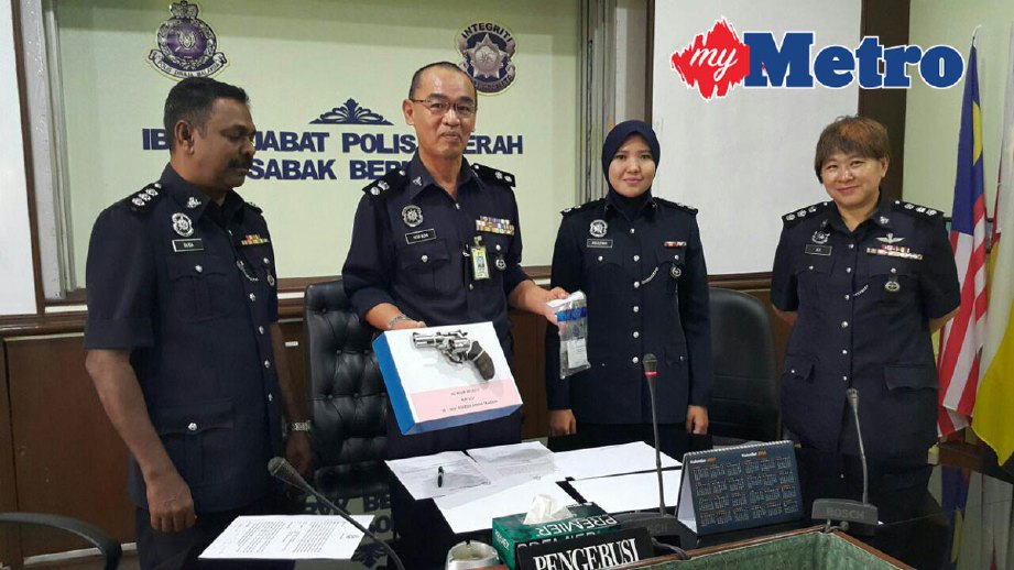 Nor Azmi menunjukkan pistol jenis Smith & Wesson yang ditemui di kebun kelapa sawit di Kampung Sungai Haji Dorani, pada sidang media di Bilik Mesyuarat Ibu Pejabat Polis Daerah Sabak Bernam, petang tadi. FOTO Mohd Shukor Amin