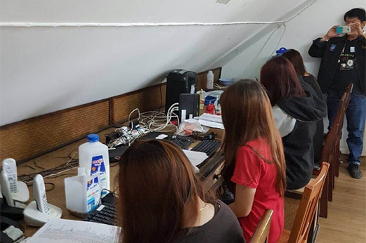 Anggota sindiket sedang membuat panggilan telefon palsu kepada mangsa ketika polis menyerbu. - Foto Bangkok Post
