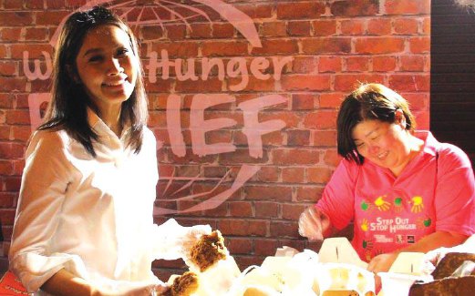 MEMBANTU membungkuskan makanan untuk kempen World Hunger Relief.