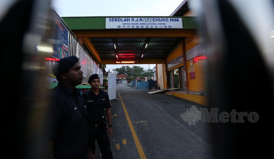 ANGGOTA polis mengawal keselamatan di perkarangan Sekolah Jenis Kebangsaan (C) Chung Hua, Rantau, sempena hari mengundi bagi Pilihan Raya Kecil (PRK) Dewan Undangan Negeri (DUN) Rantau. FOTO Iqmal Haqim Rosman.