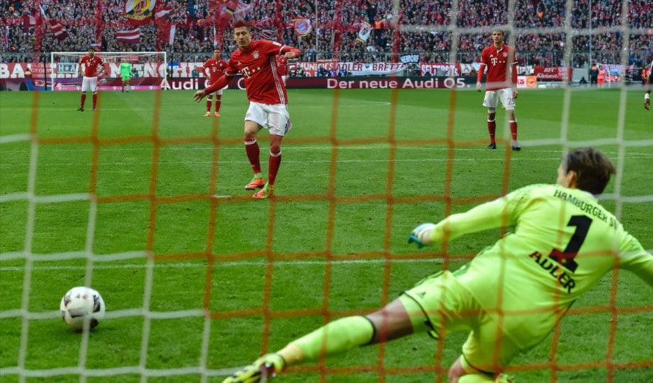 LEWANDOWSKI (kiri) jaring penalti buat Bayern.