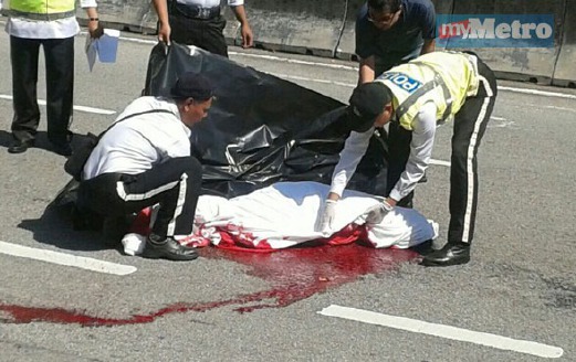 ANGGOTA polis trafik menutup mayat mangsa langgar di Jalan Tanjung Bungah, Georgetown.