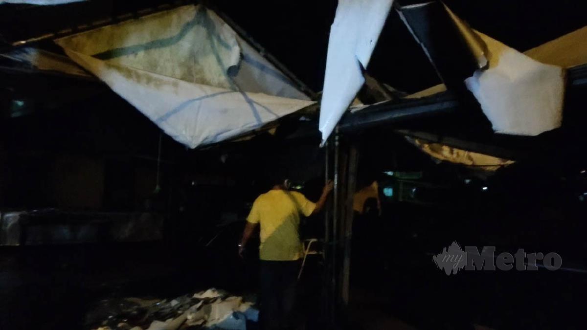 Beberapa peniaga menunjukkan khemah yang rosak teruk dilanda ribut dalam kejadian di hadapan Masjid Kampung Sireh, di sini, jam 4.30 petang, semalam. FOTO SYAHERAH MUSTAFA