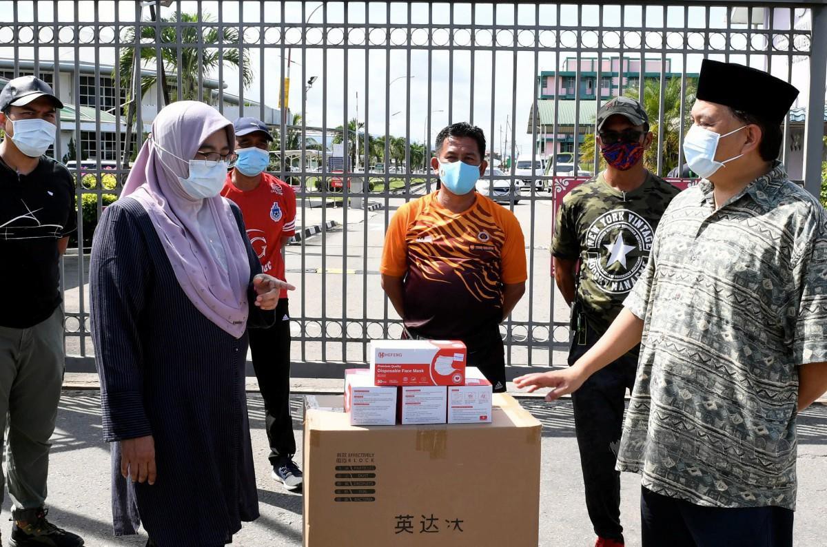 ARIFIN ketika menyampaikan sumbangan dari Pusat Zakat Sabah kepada Pengarah Penjara Negeri Sabah dan Wilayah Persekutuan Labuan Nora Musa (kiri) di pintu masuk Penjara Kepayan. FOTO BERNAMA
