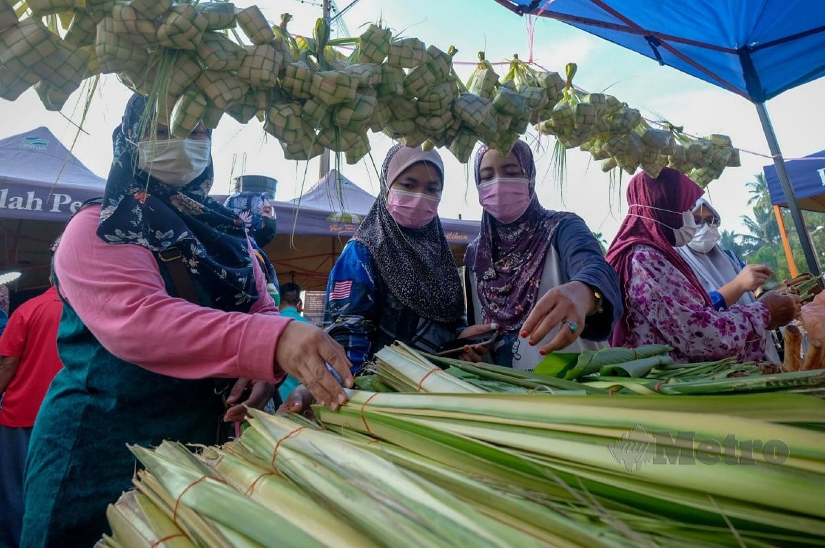 Orang ramai memilih daun kelapa serta daun palas untuk membuat ketupat ketika tinjauan persiapan sambutan Aidilfitri di Pasar Tani Alor Gajah, hari ini. FOTO BERNAMA