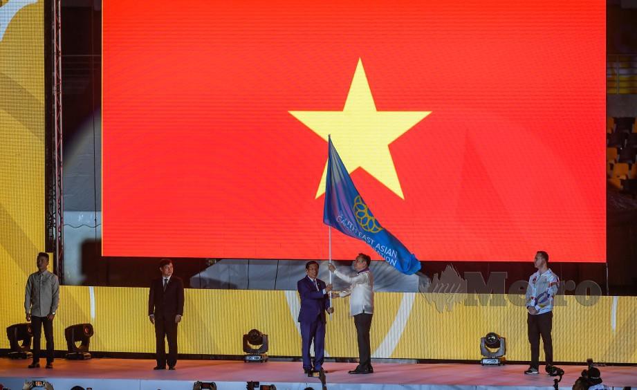 PRESIDEN Jawatankuasa Olimpik Filipina dan Presiden Persekutuan Sukan Sea, Abraham Tolentino (dua kanan) menyerahkan bendera Sukan Sea kepada Menteri Kebudayaan, Sukan dan Pelancongan Vietnam, Nguyen Ngoc Thien. — FOTO Bernama